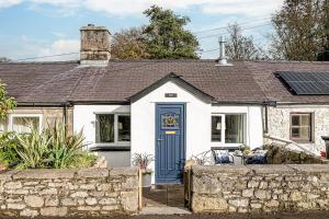 LlanfaesFisherman Cottage Llanfaes near Beaumaris的白色的小小屋,设有蓝色的门