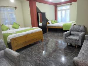 西隆Vati guesthouse的一间设有两张床和椅子的房间