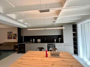 洛桑Loft industriel en duplex - The Urban Garage的厨房配有木桌和笔记本电脑
