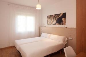 巴塞罗那Ola Living Sagrada Familia的一间卧室设有两张白色的床和窗户
