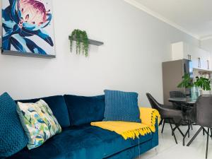 温特和克Essence Lifestyle Self-Catering Accommodation - Academia的客厅配有一张蓝色的沙发,配有一张桌子