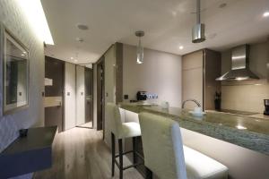 迪拜Livbnb - City Center Studio close to Everything的厨房配有带椅子和柜台的酒吧