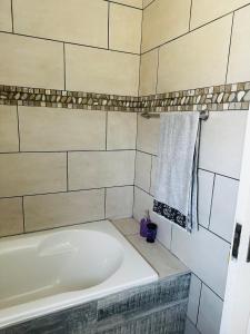 鲸湾港Euphorie的带浴缸和墙上毛巾的浴室