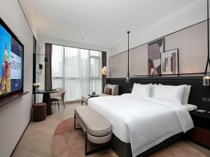 温州温州丽亭酒店的酒店客房设有一张白色大床和电视。