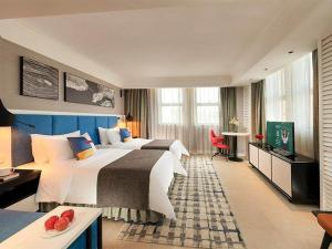 北海丽柏酒店北海银滩万达广场店的酒店客房设有两张床和电视。