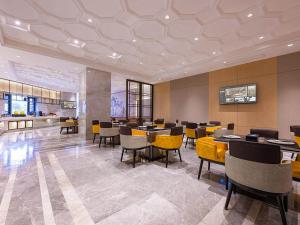 咸阳维也纳国际西安咸阳国际机场酒店的用餐室配有桌子和黄色椅子