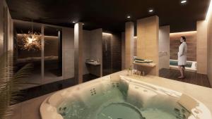 恩厄尔霍尔姆普鲁斯胡斯57贝斯特维斯特酒店的站在带浴缸的浴室中的女人