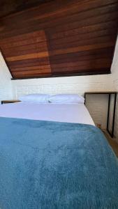 贝卢港Chalé em Bombinhas/Porto belo的一张位于带木制天花板的客房内的大床