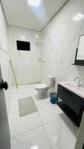 博尼图Casa com piscina的白色的浴室设有卫生间和水槽。