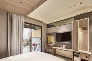 台北泰桔子商旅-西门汉中店的酒店客房设有一张床、一张书桌和一台电视机。