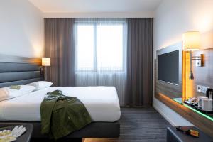 柏林柏林东站慕奇夕酒店的酒店客房设有一张大床和一台电视机。