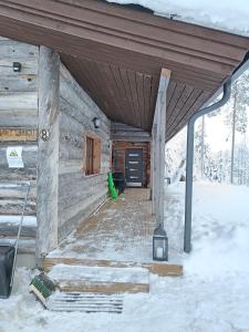 索特Mäntyharju-mökki的雪地小木屋的门廊