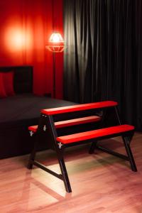 维尔纽斯BDSM Red Apartments的卧室前的红色长凳