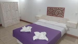 卢汉德库约POSADA DE LA LUNA的一间卧室配有一张紫色床和毛巾