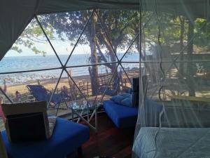 道因Glamping Dome Dauin Beach and Dive Resort的一间客房,从帐篷可欣赏到海滩美景