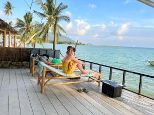 班泰Namthip Homebeach的坐在海边长凳上的人