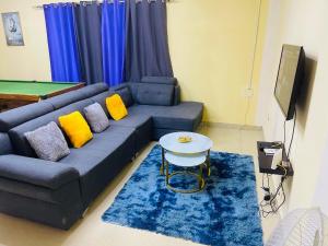 罗安达Luanda City Hostel的客厅配有蓝色沙发及黄色枕头