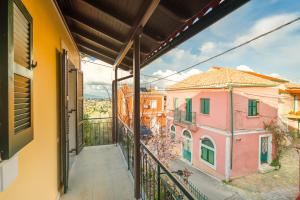 Ágios ProkópiosIoli Traditional Corfu Residence的阳台享有两栋粉红色建筑的景致。
