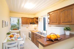 Ágios ProkópiosIoli Traditional Corfu Residence的厨房配有木制橱柜和一张带南瓜的桌子。
