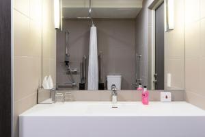 卡萨诺韦米兰马尔彭萨机场慕奇夕酒店的一间带水槽和镜子的浴室
