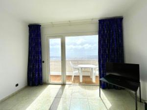 塔马达斯特Apartamento en Tamaduste con maravillosa vistas al mar的客房设有带桌子和窗户的阳台。
