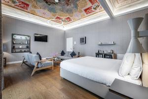 佛罗伦萨Martelli 6 Suite & Apartments的一间带白色大床的卧室和一间客厅