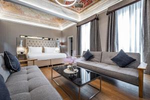佛罗伦萨Martelli 6 Suite & Apartments的客厅配有沙发和1张床