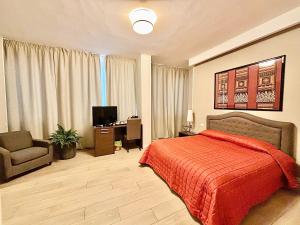 巴里Les Suites Luxury Bari Certified Italian Excellence的一间卧室配有一张床、一把椅子和电视