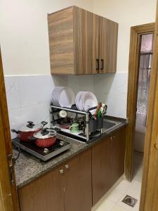 安曼Apartment for rent 50M fully furnished -completely new的厨房配有水槽和炉灶及餐具