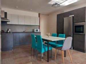 马尔萨斯卡拉Apartment in Marsaskala的厨房配有餐桌和蓝色椅子