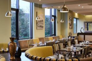 泰恩河畔纽卡斯尔Leonardo Hotel Newcastle的用餐室设有桌椅和窗户。