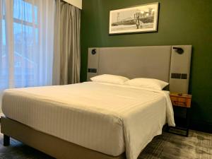 伯恩茅斯Park Inn by Radisson Bournemouth的一间卧室配有一张白色的床和绿色的墙壁