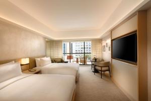 新加坡Conrad Singapore Orchard的酒店客房设有两张床和一台平面电视。