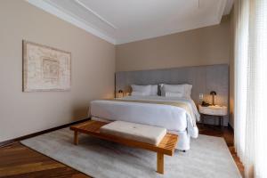 坎波斯杜若尔当坎波斯约丹山庄大酒店的卧室配有一张白色的大床和一张桌子