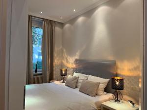 汉诺威Suite Appartement Friesenhof的一间卧室配有一张带两盏灯的大型白色床。
