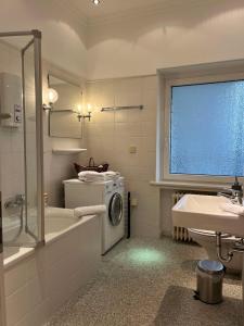 汉诺威Suite Appartement Friesenhof的一间带洗衣机和水槽的浴室