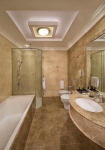 阿布扎比Royal Rose Abu Dhabi, a Curio Collection by Hilton Affiliated Hotel的一间带两个盥洗盆、浴缸和卫生间的浴室