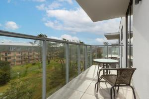 梅尔诺Apartamenty Jantaris II by Renters的设有一个配有桌椅并享有美景的阳台。