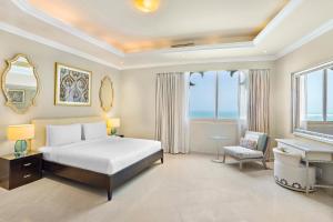 拉斯阿尔卡麦Al Hamra Residence的卧室配有床、书桌和钢琴