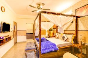 大诺伊达House Of Comfort Greater Noida Luxury的一间卧室配有一张天蓬床和吊扇
