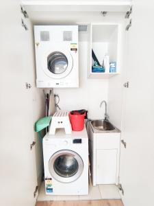 悉尼Cozy Apartment at St Leonard的小厨房配有洗衣机和水槽