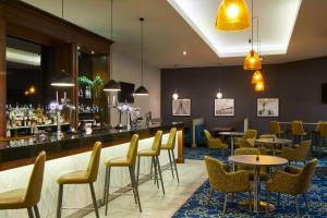 米德尔斯伯勒Leonardo Hotel Middlesbrough的一间带桌椅的餐厅和一间酒吧