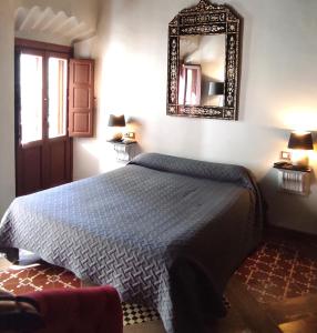 卡塞雷斯波希米亚酒店的卧室配有一张床,墙上设有镜子
