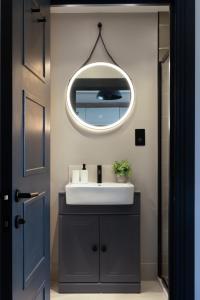 海斯廷斯Vive Hotel的一间带水槽和镜子的浴室