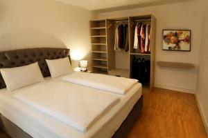 海德堡Boardinghotel Westarkaden Suites的一间卧室配有一张大床和一个衣柜