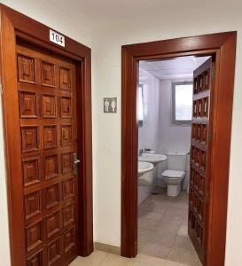 萨拉戈萨Albergue Zaragoza Camping的浴室设有门、卫生间和水槽。