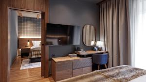 兹拉蒂博尔Bor Hotel by Karisma的一间卧室配有一张床和一张带镜子的书桌