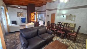 巴尔内阿利奥埃尔康多尔Sonidos del Mar的一间带真皮沙发的客厅和一间餐厅