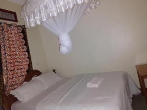 KisoroSAWA SAWA GUEST HOUSE的卧室配有带窗帘的白色床