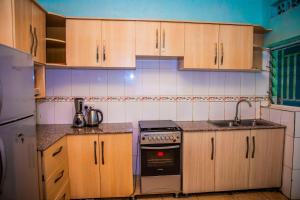 基加利RIGTH Homes的厨房配有木制橱柜和炉灶烤箱。